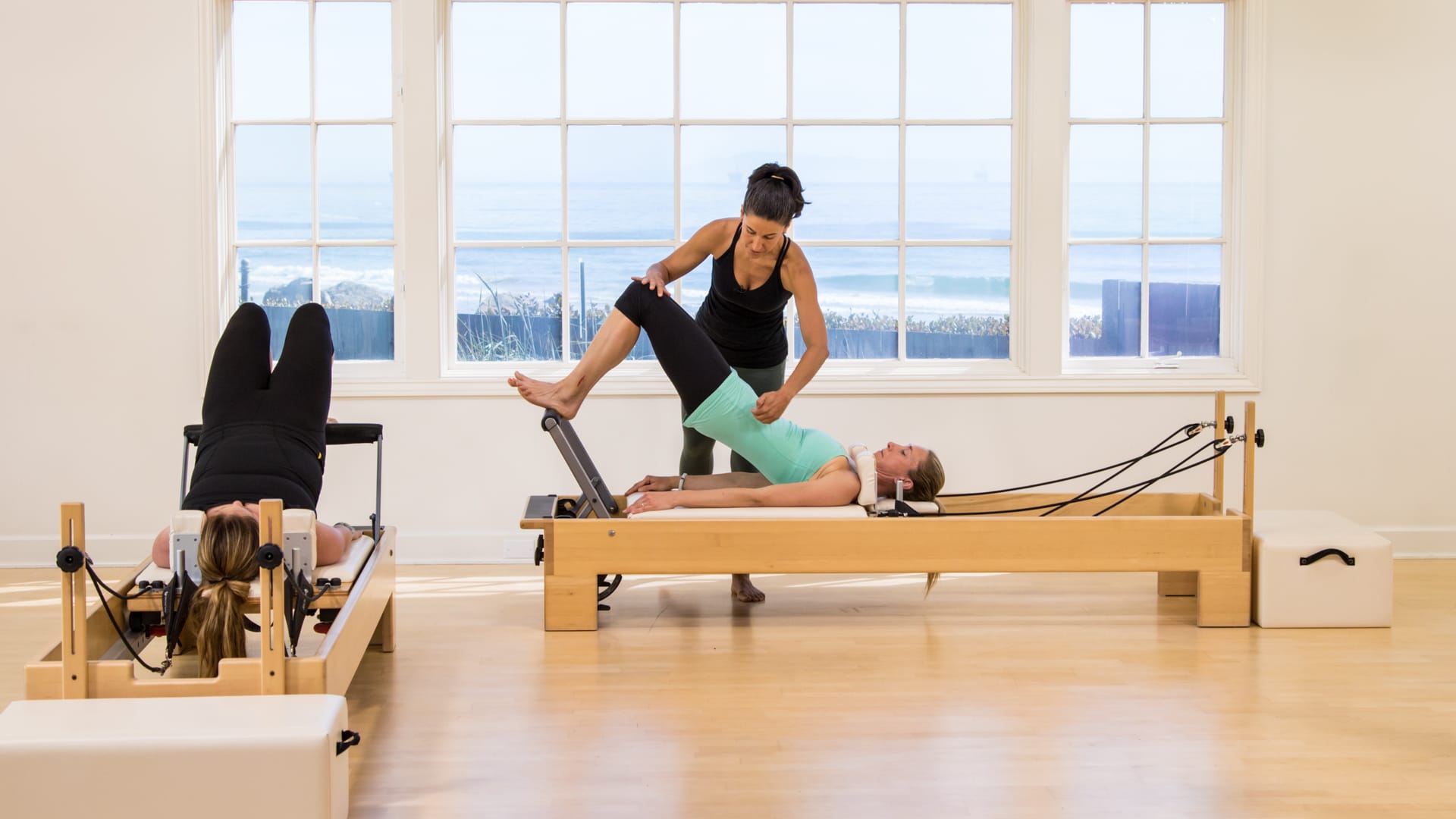 Polestar Senior Educator Christi Idavoy instructing a student on the Pilates Reformer for a master class.